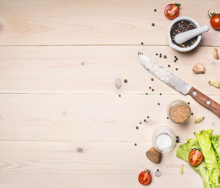 Healthy foods, cooking and vegetarian concept cherry tomatoes, lettuce, spices and unground pepper, knife, Border, place for text on wooden rustic background top view close upの写真素材