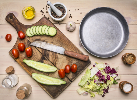 Superfoods and healthy lifestyle or detox diet food concept Ingredients for cooking vegetarian salad with herbs and butter cucumbers, peppers, cherry tomatoes and garlicの写真素材