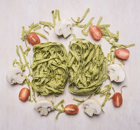Superfoods and health or detox diet food concept green pasta with spinach and cherry tomatoes, laid out on a white wooden rustic backgroundの写真素材