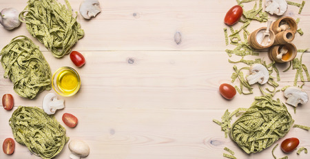 Concept of cooking vegetarian green pasta with cherry tomatoes, seasoning, garlic and butter, lined with a frame, space for textの写真素材
