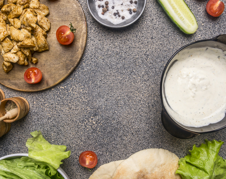 Ingredients for cooking home-made shawarma, fried chicken with condiments, pita, sliced ??cucumbers, condiments and spices, Lined with a frame on a granite table, place for textの写真素材