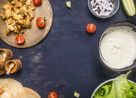 Ingredients for cooking the home Shaverma, fried chicken, condiments, vegetables and seasonings, lined with a frame on a rustic wooden background, space for textの写真素材
