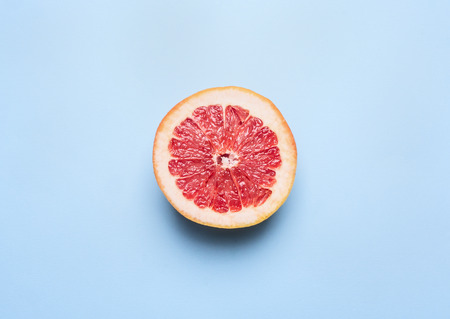 Ripe bright orange grapefruit on a blue background, top viewの写真素材