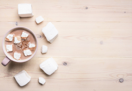 Cocoa in a pink cup with giant homemade marshmallow, on white wooden background, space for textの写真素材