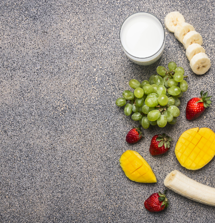 Superfoods and health or detox diet food concept. Ingredients for smoothies from bananas, mangoes, strawberries and grapes, border, place for textの写真素材