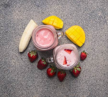 Red smoothie bottle with straw and ingredients on granit background, top view, close up. Healthy lifestyle and detox or diet food conceptの写真素材