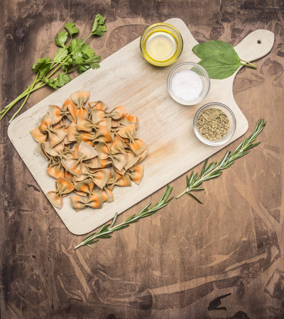 Concept of cooking Italian vegetarian pasta with cherry tomatoes, herbs, seasonings and butter on a cutting board, space for text, borderの写真素材