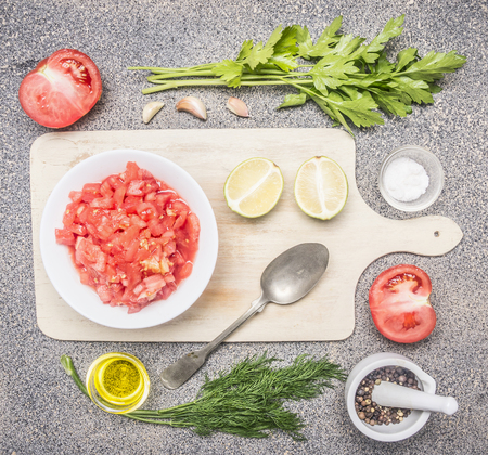 Ingredients for the preparation of cold tomato soup, sliced ââtomatoes, greens, oil, garlic, black pepper, on a rustic granite backgroundの写真素材