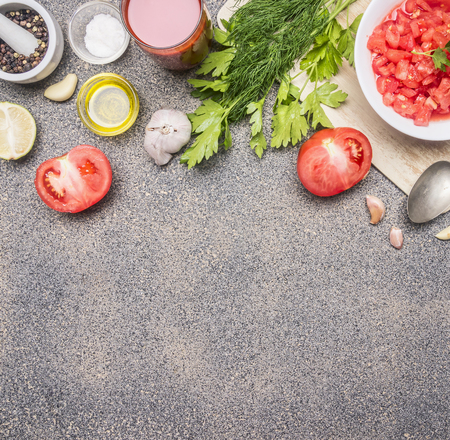 Ingredients for the preparation of cold tomato soup, sliced ??tomatoes, greens, oil, garlic, black pepper, on a rustic granite background Place for text borderの写真素材