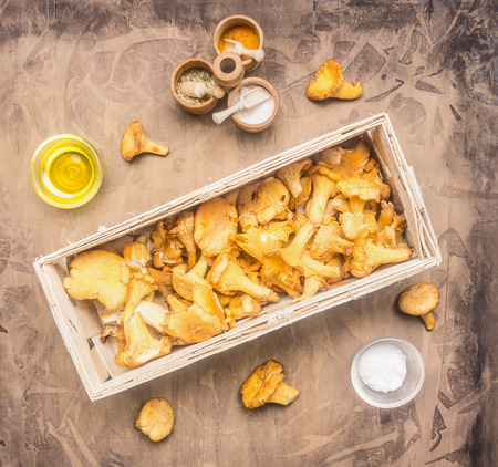 fresh raw chanterelles in a basket, with herbs and spices laid out, concept of cooking mushrooms, top viewの写真素材