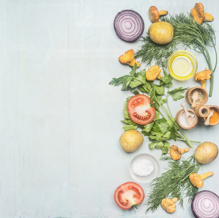 Ingredients for cooking chanterelles with vegetables and herbs, laid out on a blue rustic background, space for text borderの写真素材