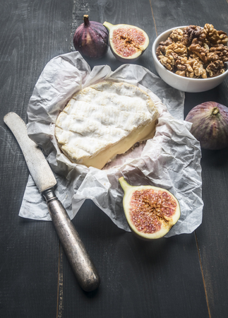 concept snacks for wine, camembert cheese, fresh sliced ??figs, vintage table knife, on rustic wooden dark backgroundの写真素材