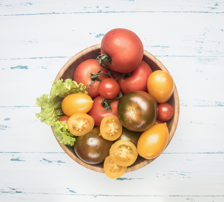 Colorful various of organic farm vegetables different varieties of tomatoes, fresh vegetables in a wooden bowl on a rustic background, top viewの写真素材