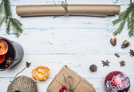 New Year or Christmas concept, roll wrapping paper, mulled wine cup, gift wrapped, tangle of twine, Christmas toys, mandarins, on a white wooden rustic background, frame, top view, space for textの写真素材