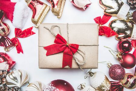 New Year or Christmas composition, various toys, decorations, bows, Christmas bells, lined around the gift, on white background, top viewの写真素材
