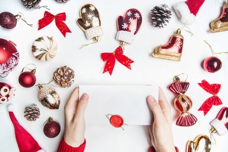 Christmas or New Year composition, toys, cones, ornaments, lined around an envelope that the girl in a red sweater, on a white background, the top viewの写真素材