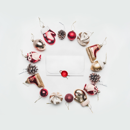 different Christmas toys and ornaments for christmas, lined with round frame with an envelope with congratulations in the middle, on a white background, top viewの写真素材
