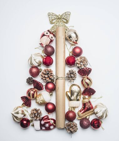 Christmas tree laid out of New Year's decorations, kraft paper for packing gifts and toys on a white background, top viewの写真素材