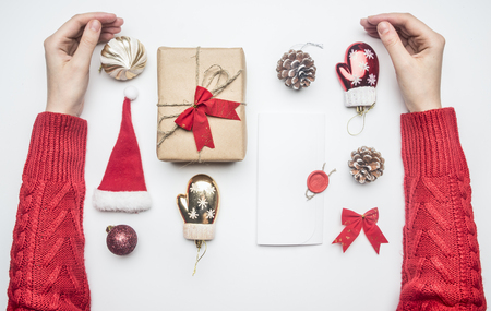 Christmas flat lay girl hugs a gift, Santa Claus hat, envelope and toysの写真素材