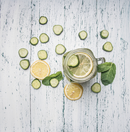 cooking healthy lemonade with cucumber, lemon and mint on a white rustic wooden background, top view flat layの写真素材