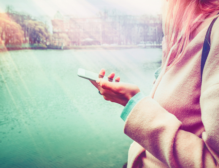 Beautiful young hipster woman using smart phone at parkの写真素材