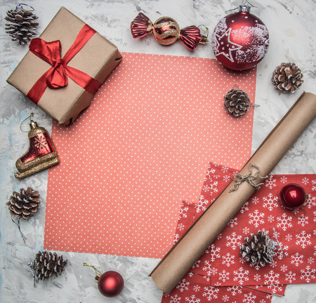 Christmas and New Year concept, Christmas decorations, gifts and cones lined around the red wrapping paper, place for textの写真素材