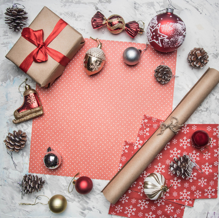 Christmas and New Year concept, Christmas decorations, gifts and cones lined around the red wrapping paper, place for textの写真素材