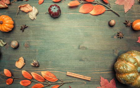 autumn composition, yellow leaves, small pumpkins frame on a wooden background, space for text flat layの写真素材