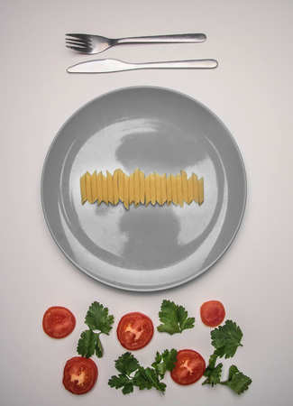 simple food, tomatoes, parsley and penne pasta on a gray plate, lined on a white background, top view, flat layの写真素材