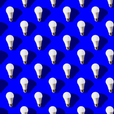 seamless pattern. white lightbulbs is up on dark blue background. geometric arrangement of objects. geometrically correct arrangementの写真素材