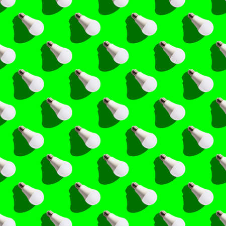 seamless pattern. white lightbulbs is right down on green background. geometric arrangement of objects. geometrically correct arrangementの写真素材