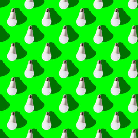 seamless pattern. white lightbulbs is down on green background. geometric arrangement of objects. geometrically correct arrangementの写真素材