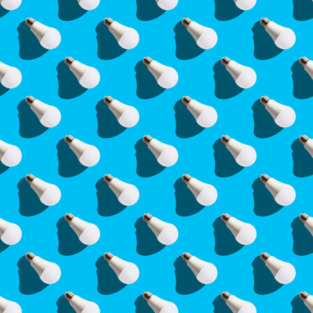 seamless pattern. white lightbulbs is right down on light blue background. geometric arrangement of objects. geometrically correct arrangementの写真素材