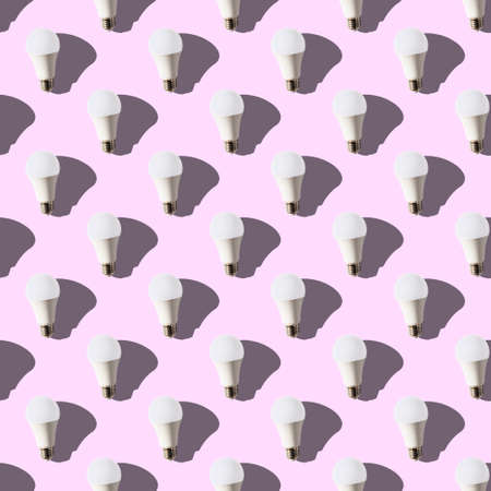 seamless pattern. white lightbulbs is up on pink background. geometric arrangement of objects....