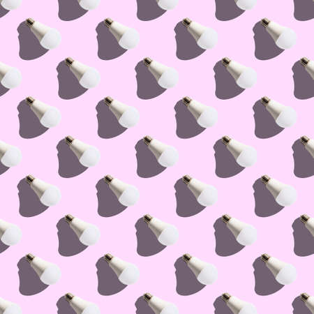 seamless pattern. white lightbulbs is right down on pink background. geometric arrangement of objects. geometrically correct arrangementの写真素材