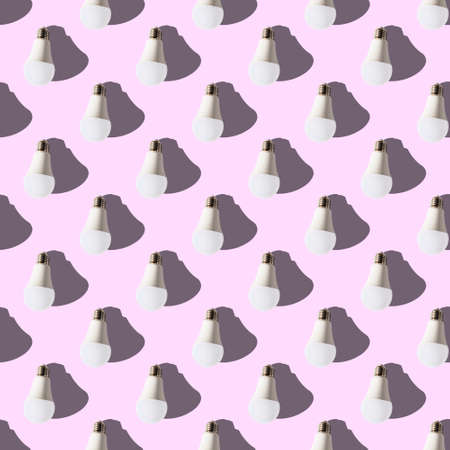 seamless pattern. white lightbulbs is down on pink background. geometric arrangement of objects. geometrically correct arrangementの写真素材