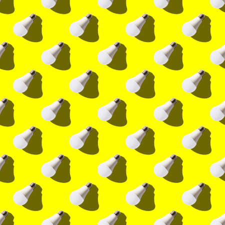 seamless pattern. white lightbulbs is left down on yellow background. geometric arrangement of...