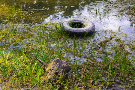 The old wheel, thrown into a dried-up lakeの写真素材