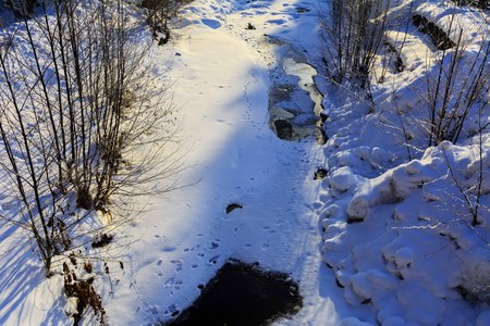 Warm water on the ice of a frozen lake covered with ice in winter