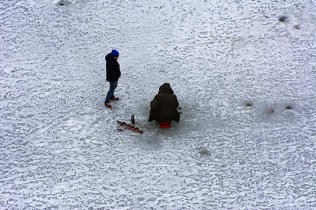 Fishermen on the river in winter ice fishing before the ice meltingの写真素材