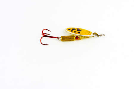 Exhibition of pirated copies of fishing metal spoon baits. Bait for fishing in the shape of a spoon with a hook on a white backgroundの写真素材