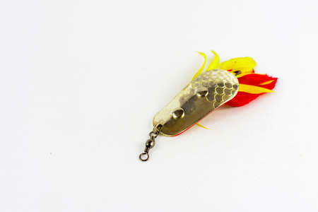 Exhibition of pirated copies of fishing metal spoon baits. Bait for fishing in the shape of a spoon with a hook on a white backgroundの写真素材