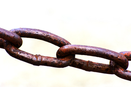 Old metal chain on a light background in sunlight
