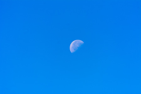 Moon in the sky on a sunny day in a bright blue sky