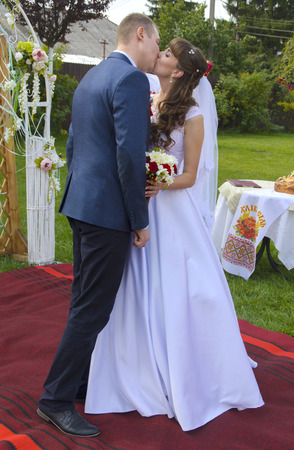 Beautiful and happy young bride and groom in wedding dress on a sunny day. Ukrainian wedding, culture, ethical traditions, concept. Autumn of 2017.のeditorial素材