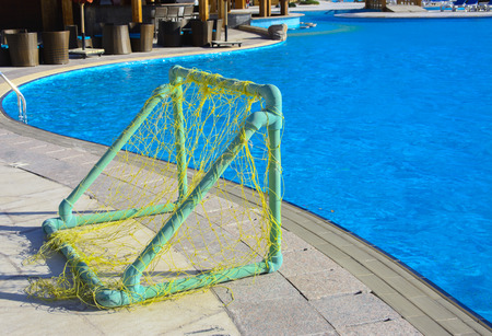 Sharm el-Sheikh, Egypt - March 14, 2018. The gate with a grid for playing water polo with a ball on the edge of the pool in the Grand Hotel Kirin with clear blue water.のeditorial素材