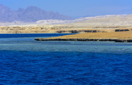 Elevated above sea level, beautiful coral reefs the form mountains and rocks against the blue sky and clear sea water coast of the unique Ras Mohammed nature reserve. Magnificent diving, summer, rest.の写真素材