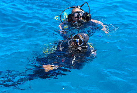 Sharm el-Sheikh, Egypt - March 14, Divers on the clear and turquoise Red Sea on immersion in beautiful corals and colorful fish. The teacher teaches the student the rules of immersion water, vacationのeditorial素材