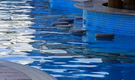 Sharm el-Sheikh, Egypt - March 14, 2018.  Beautiful pool in Cyrene Grand Hotel with clear blue water on the background of the sea, blue sky and green palm trees. Beach chaise longue.のeditorial素材
