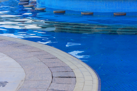Sharm el-Sheikh, Egypt - March 14, 2018.  Beautiful pool in Cyrene Grand Hotel with clear blue water on the background of the sea, blue sky and green palm trees. Beach chaise longue.のeditorial素材
